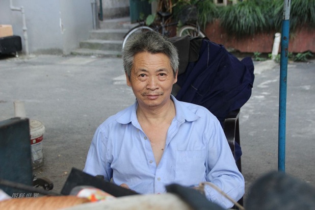 今年55岁的戴金炉大伯的修鞋摊，就摆在杭州城西文一路和古翠路的交叉口，靠东南角的翠苑四区一个封闭的铁栏门里面
