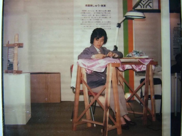 1982年，日本静冈县有一场刺绣表演，绣架前，一位手绣大师将一根细丝绒一劈再劈，劈出100多缕，穿过针眼的一缕丝线几乎肉眼难见