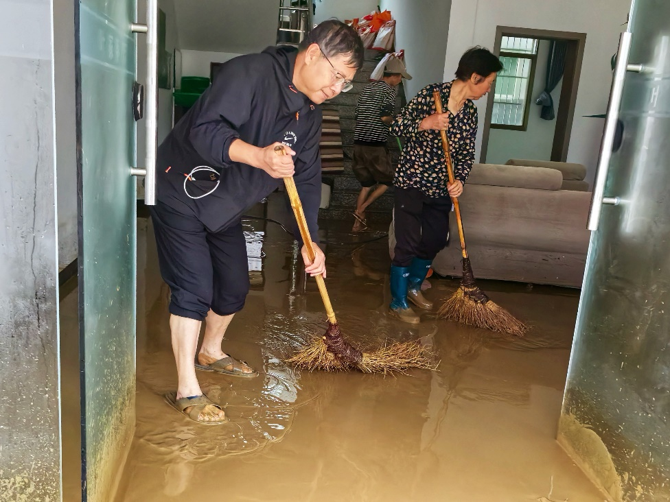 (王暨平和村民一起清理淤泥。) 配图7
