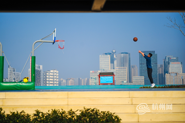 同时,相关部门积极推动篮球进校园、进社区、进企业,开展专业教练公益授课、篮球技能培训等活动,为篮球运动的普及奠定坚实基础。图为钱塘江边,一位市民正在江边公园打篮球 配图16