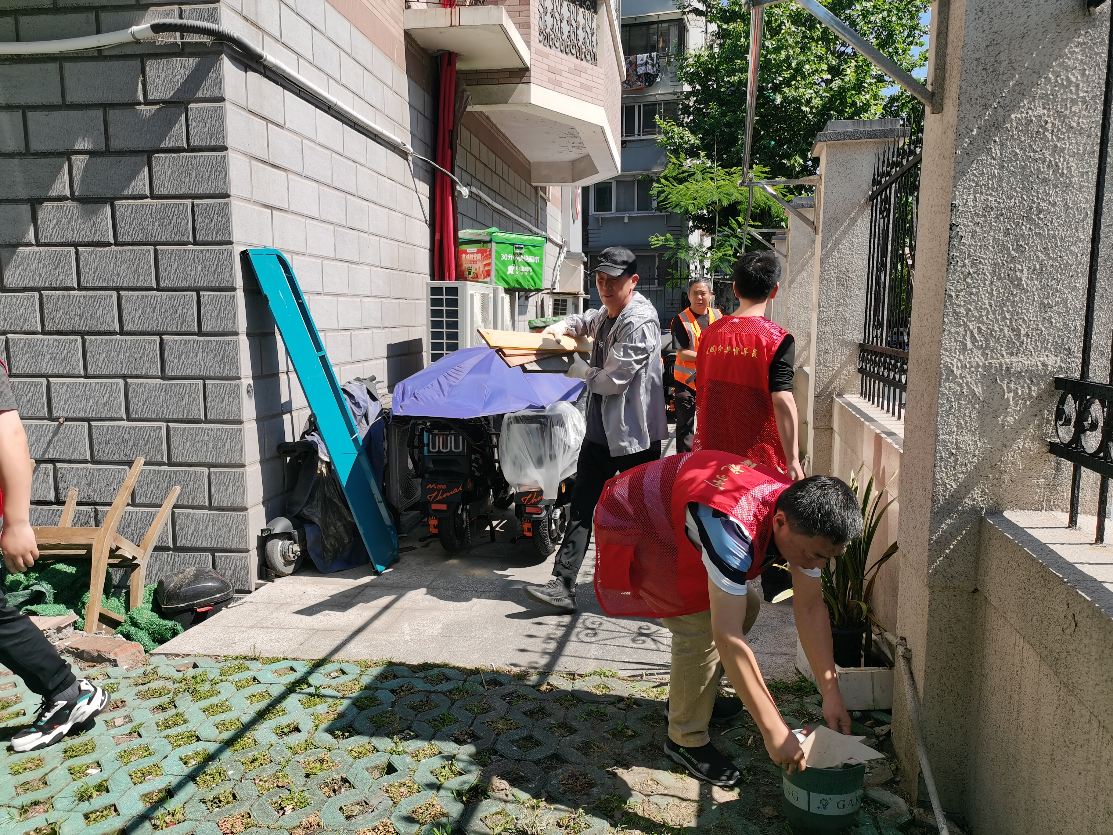 物业保洁人员和志愿者根据工单清理小区堆积物。受访单位供图 配图4